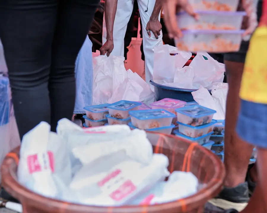 Volunteers gathering packed meals in large bowls