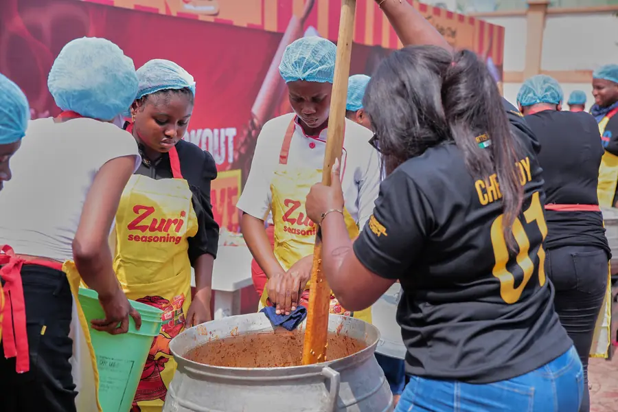 Cooks preparing food around a large pot at a Sábi Chẹf event