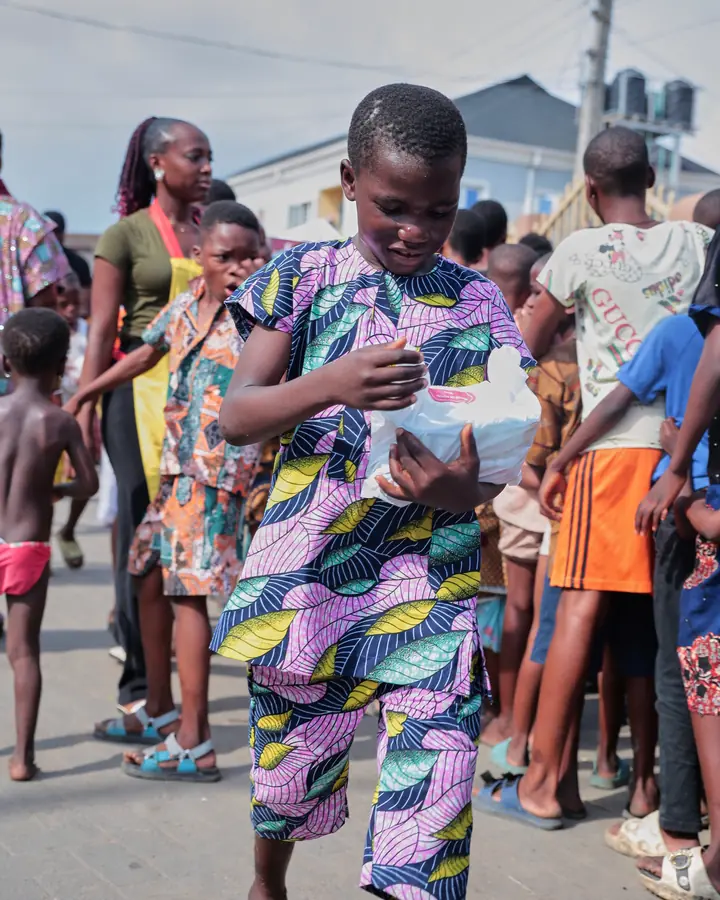 A child standing with a meal pack at the event