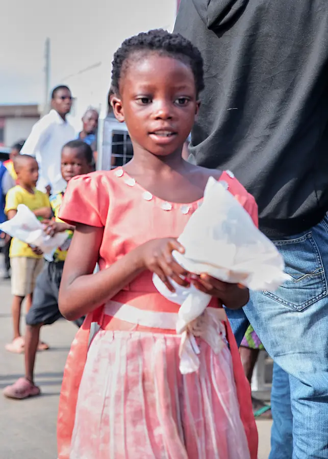 A young girl holding her food pack with both hands