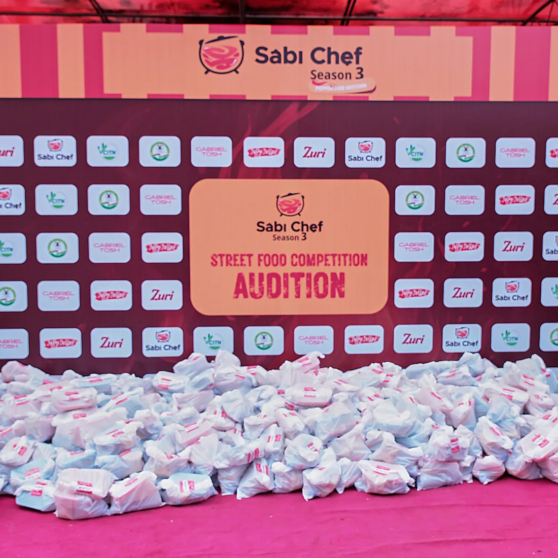 A mountain of packed food bags in front of the Sábi Chẹf Season 3 audition stage